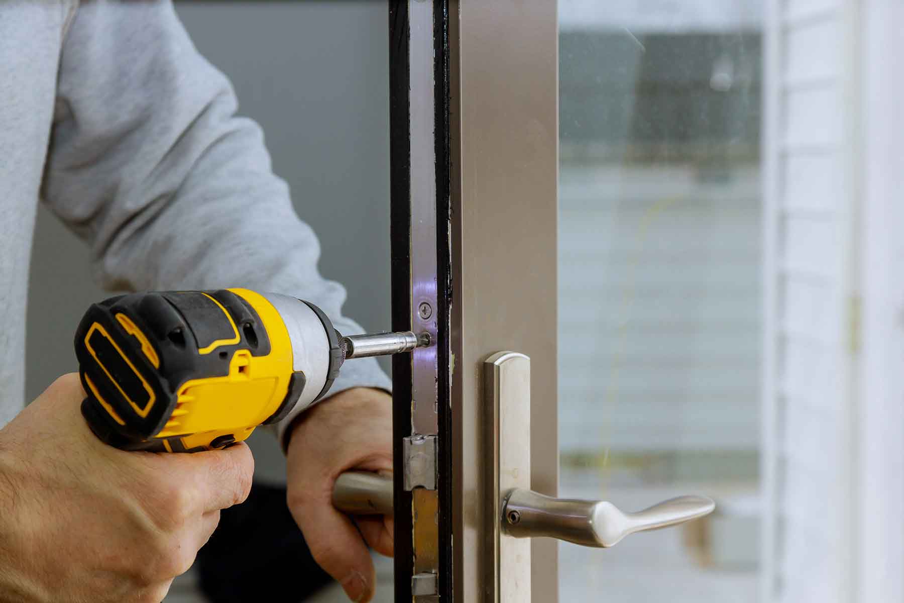 locksmith-in-installing-new-house-door-lock-hand-h-XVHVTG4