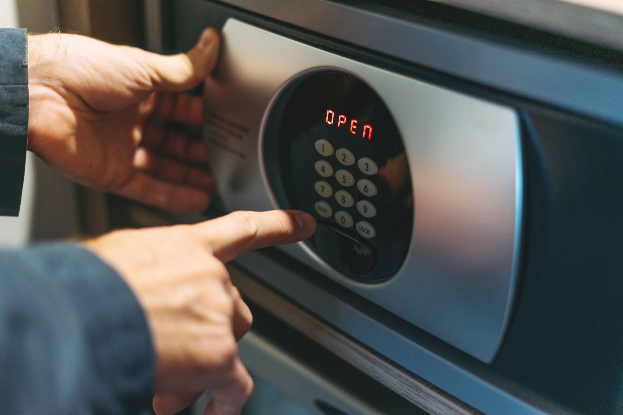 adult-man-in-blue-jacket-uses-safe-in-the-hotel-ro-9R4SVGY-1.jpg